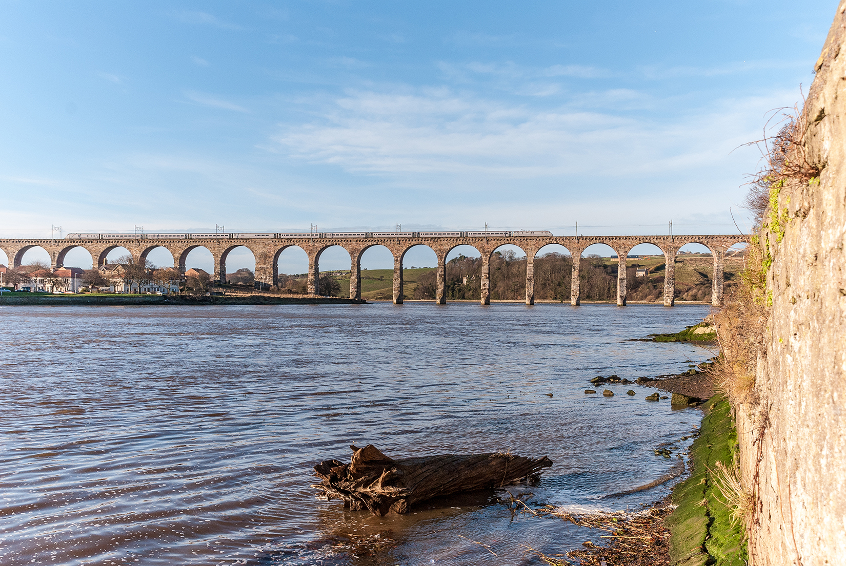 An East Coast Mainline train heading north across the Royal Border Bridge